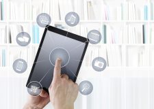 hand touching digital tablet with icons isolated on library background